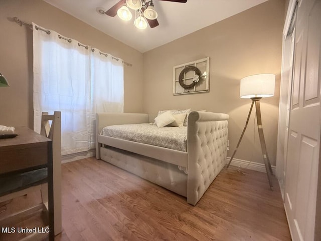 bedroom with ceiling fan, baseboards, and wood finished floors