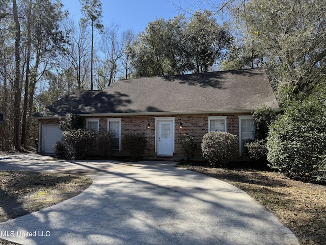 view of front of home with brick siding, driveway, an attached garage, and roof with shingles