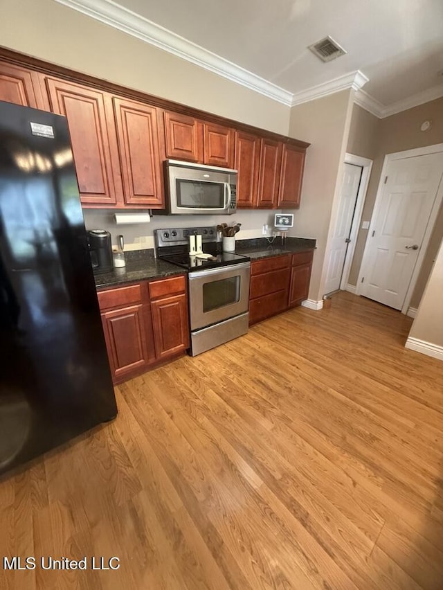 kitchen with stainless steel appliances, visible vents, light wood-style floors, ornamental molding, and baseboards