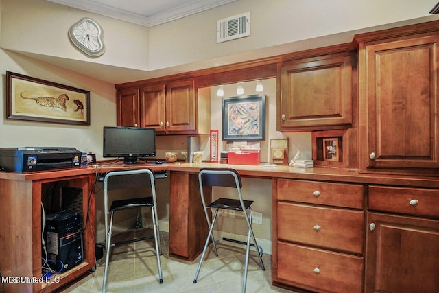 office area with visible vents, built in desk, and ornamental molding