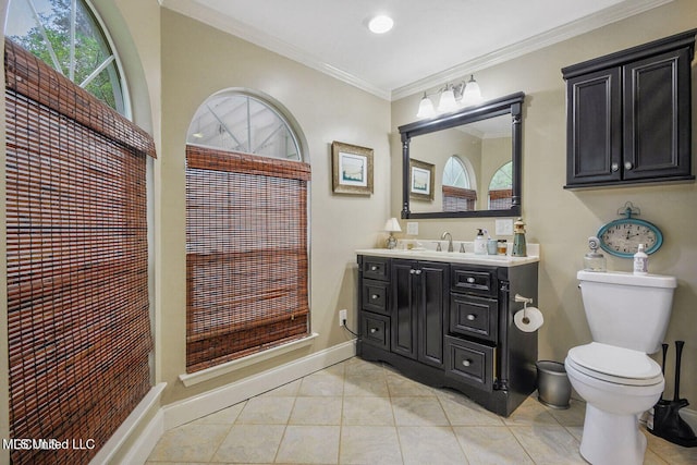 bathroom with vanity, baseboards, ornamental molding, tile patterned flooring, and toilet