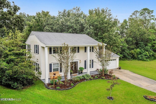 greek revival house featuring an attached garage, concrete driveway, a front lawn, and a shingled roof