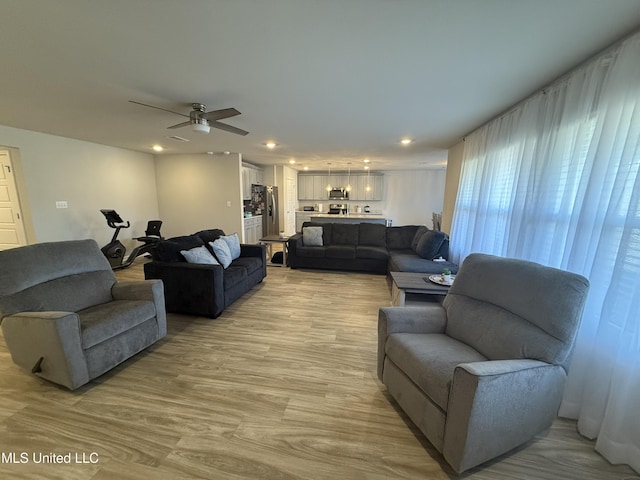 living room with ceiling fan and light hardwood / wood-style floors