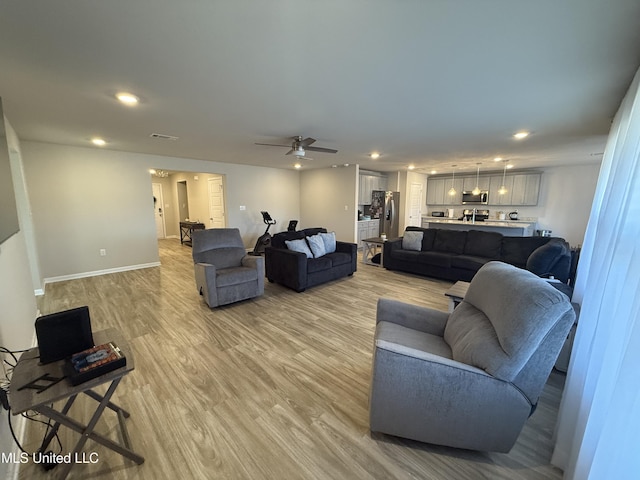 living room featuring ceiling fan and light hardwood / wood-style floors