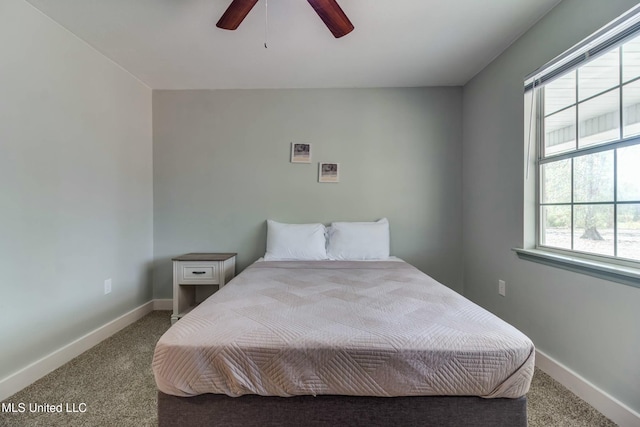 carpeted bedroom featuring ceiling fan and multiple windows