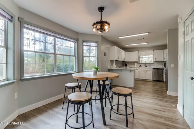 dining room featuring light wood-type flooring and sink