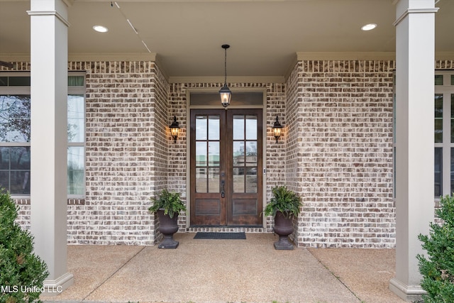 property entrance featuring brick siding and french doors