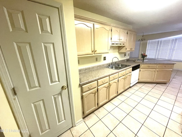 kitchen featuring a sink, white dishwasher, a peninsula, and light tile patterned flooring