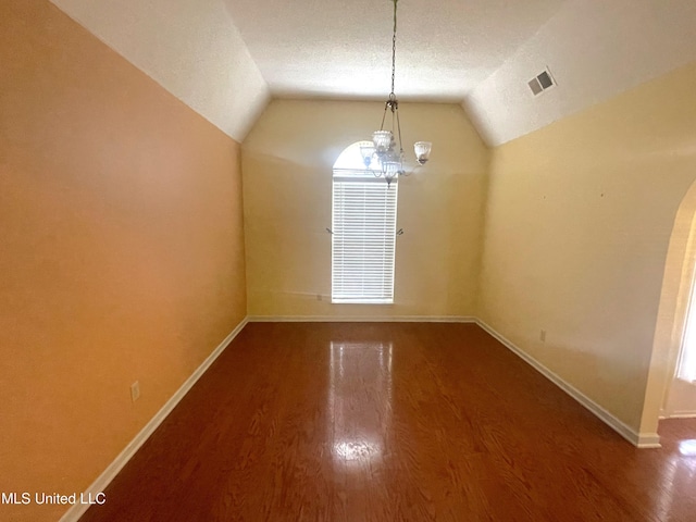 unfurnished dining area featuring baseboards, visible vents, and wood finished floors