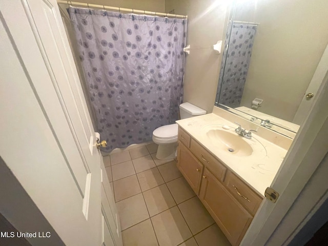full bath with a shower with curtain, tile patterned floors, vanity, and toilet