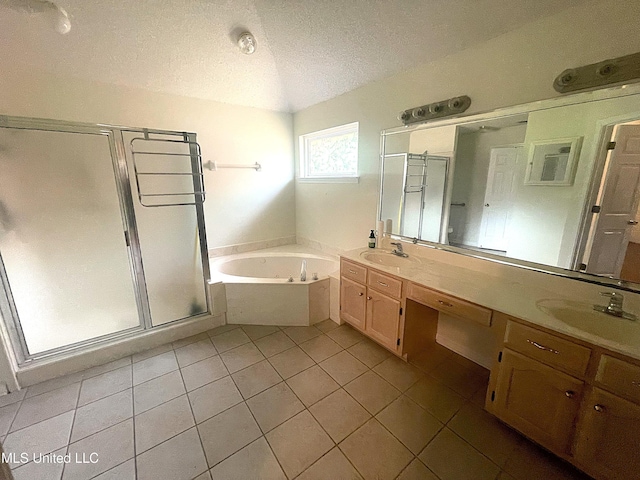 full bath featuring a sink, tile patterned flooring, a textured ceiling, a bath, and a stall shower