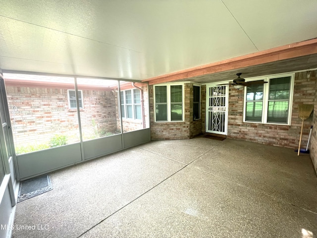 unfurnished sunroom with ceiling fan