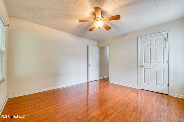 7643 Broken Hickory Dr, Walls, MS 38680 - unfurnished bedroom featuring light wood-style flooring, baseboards, a textured ceiling, and a ceiling fan