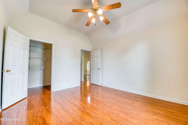 7643 Broken Hickory Dr, Walls, MS 38680 - unfurnished bedroom with lofted ceiling, arched walkways, light wood-style floors, a closet, and baseboards