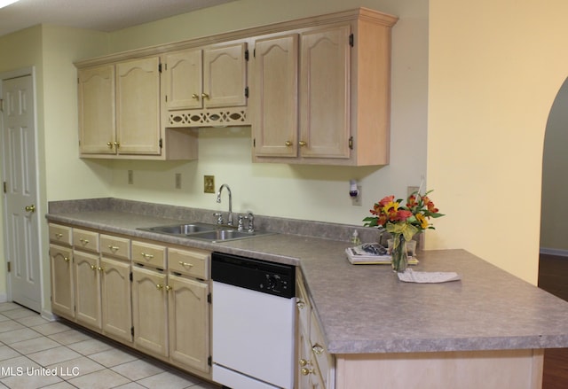 kitchen featuring a peninsula, arched walkways, light tile patterned floors, a sink, and dishwasher