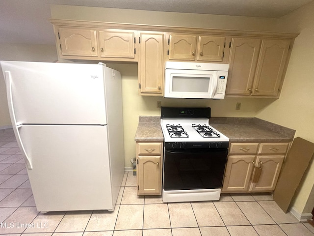 kitchen with baseboards, light tile patterned flooring, and white appliances