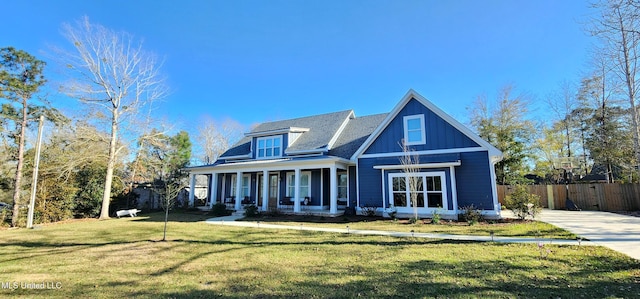 view of front of property featuring board and batten siding, a porch, a front yard, and fence