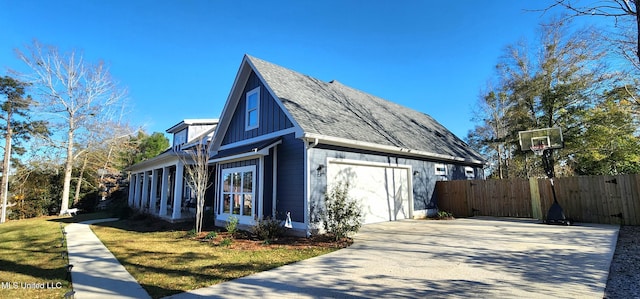 view of side of home with fence, board and batten siding, concrete driveway, a shingled roof, and a garage