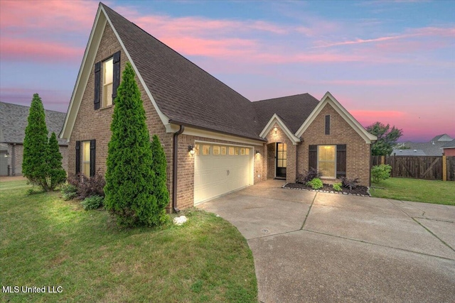 traditional home featuring brick siding, concrete driveway, a shingled roof, and an attached garage