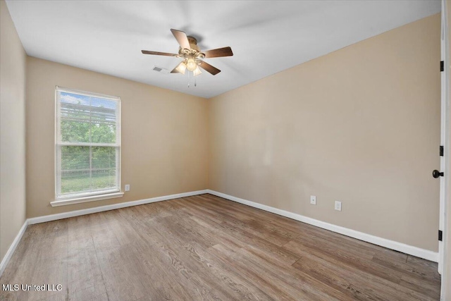 spare room featuring wood finished floors, baseboards, and a ceiling fan