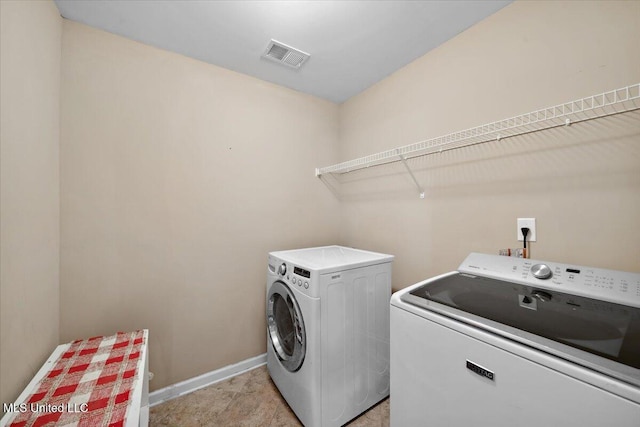 laundry area with washer and clothes dryer and baseboards