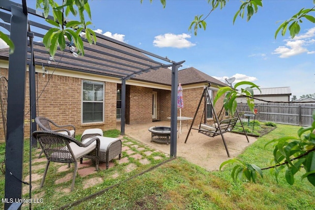 rear view of house with a pergola, an outdoor fire pit, a patio, fence, and brick siding