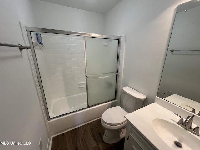 full bathroom with shower / bath combination with glass door, wood-type flooring, vanity, and toilet