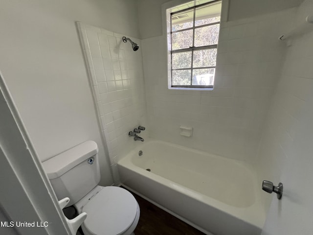 bathroom featuring tiled shower / bath combo and toilet