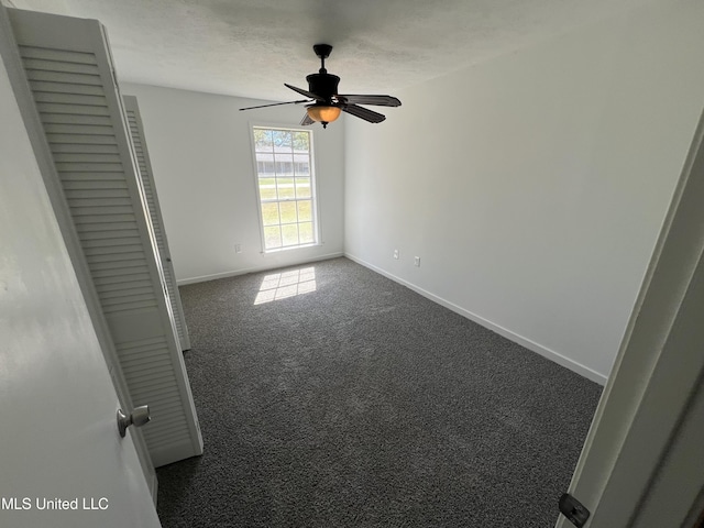 unfurnished room featuring ceiling fan, carpet floors, and a textured ceiling