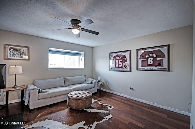 living room featuring baseboards, a textured ceiling, ceiling fan, and wood finished floors