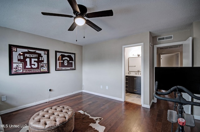 bedroom featuring dark wood-type flooring, baseboards, a textured ceiling, and visible vents