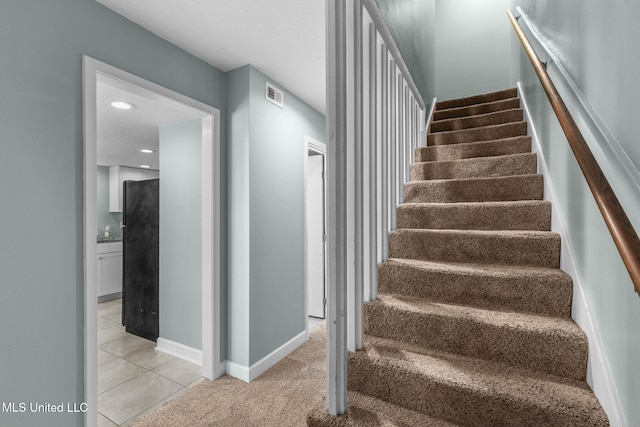 stairway featuring visible vents, tile patterned flooring, baseboards, carpet floors, and recessed lighting