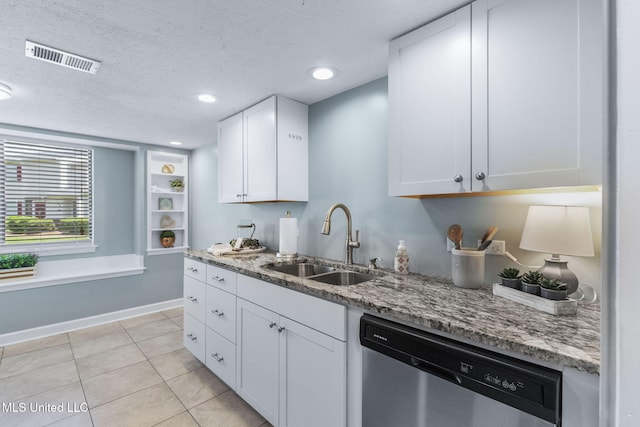 kitchen with light stone counters, visible vents, a sink, and dishwasher
