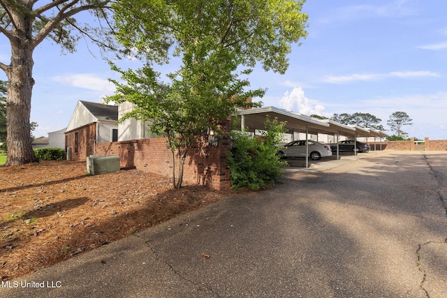 view of front of house featuring brick siding and covered parking