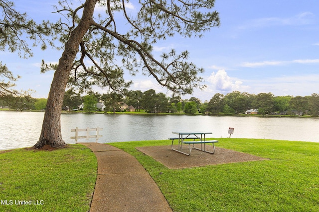 view of home's community featuring a lawn and a water view