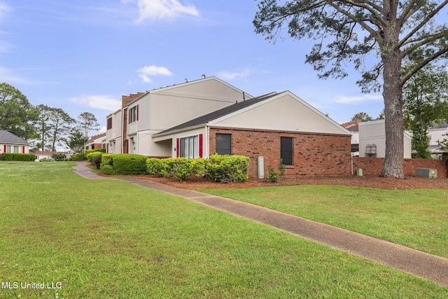 view of side of home with brick siding and a lawn