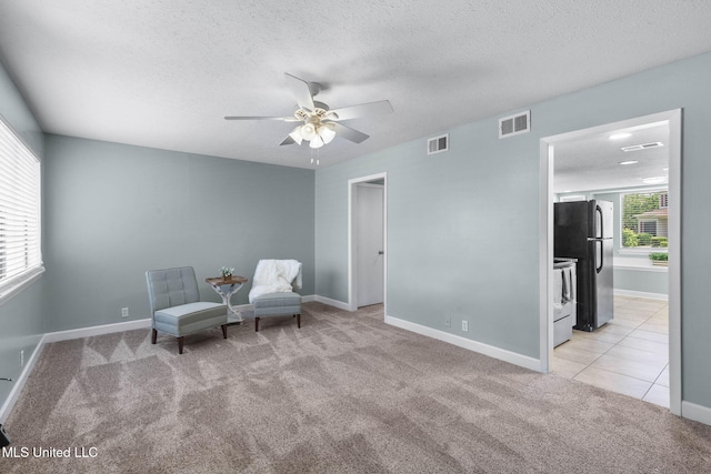 sitting room featuring light carpet, a ceiling fan, and visible vents