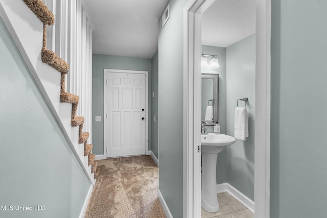 bathroom featuring visible vents, a sink, and baseboards