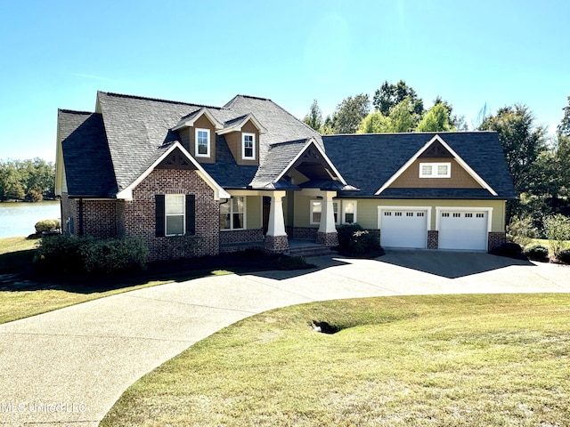 craftsman house with a front yard, a garage, and covered porch