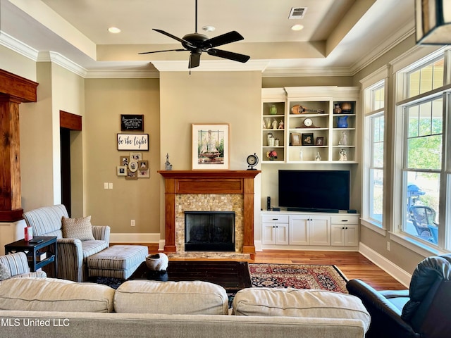 4 Mallard Xing, Raymond, MS 39154 - living room featuring light wood-type flooring, a tray ceiling, a ceiling fan, baseboards, and a high end fireplace