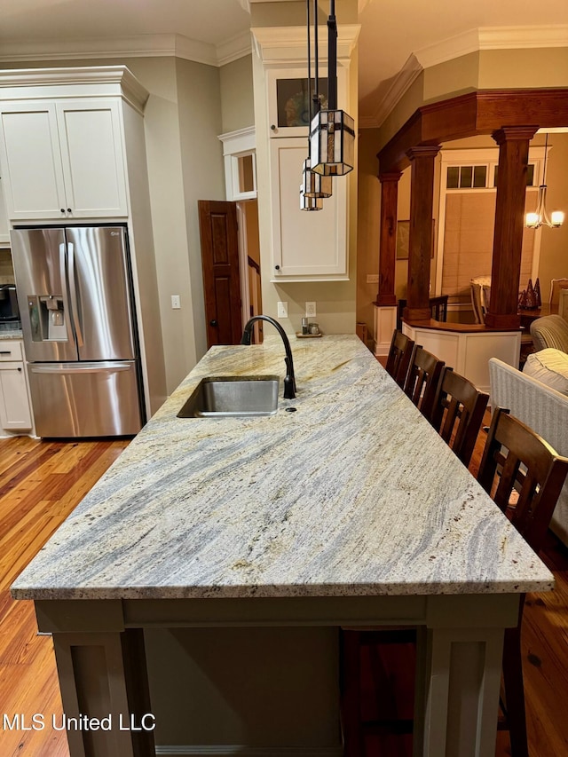 4 Mallard Xing, Raymond, MS 39154 - kitchen featuring stainless steel refrigerator with ice dispenser, a sink, ornate columns, light wood finished floors, and crown molding