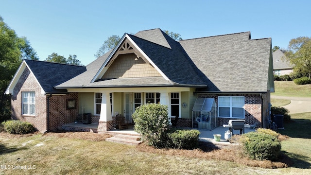 4 Mallard Xing, Raymond, MS 39154 - view of front of property with brick siding, covered porch, a front lawn, roof with shingles, and central air condition unit