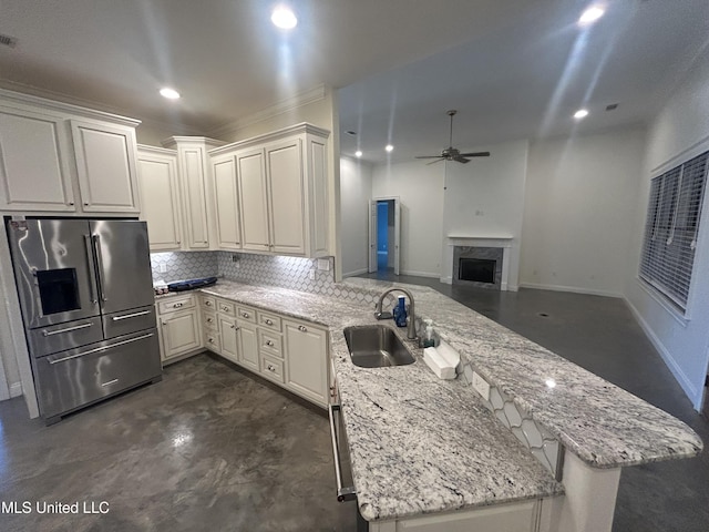 1306 Robert E Lee Dr, Greenwood, MS 38930 - kitchen featuring stainless steel fridge with ice dispenser, a peninsula, a high end fireplace, a ceiling fan, and tasteful backsplash