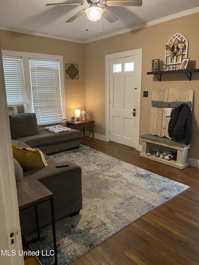 living room featuring ceiling fan, dark wood-type flooring, a textured ceiling, and ornamental molding