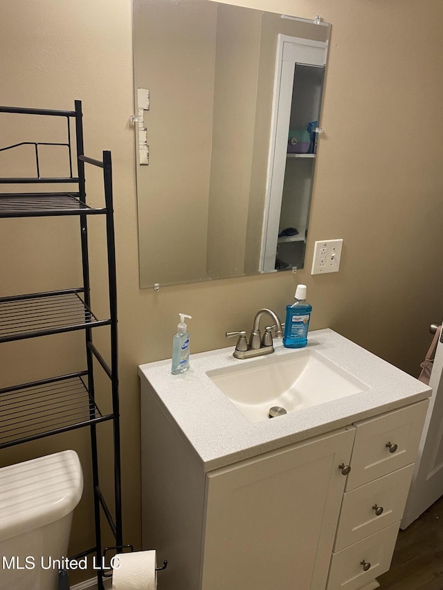 bathroom featuring vanity, hardwood / wood-style flooring, and toilet