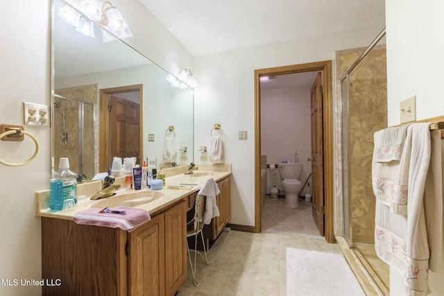 bathroom with a shower with door, a textured ceiling, toilet, and vanity