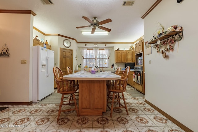 dining space featuring a textured ceiling, ceiling fan, and ornamental molding