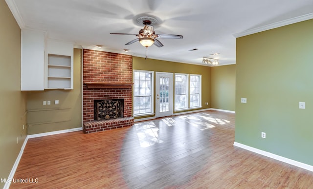 unfurnished living room featuring ceiling fan, ornamental molding, light wood-type flooring, and a fireplace