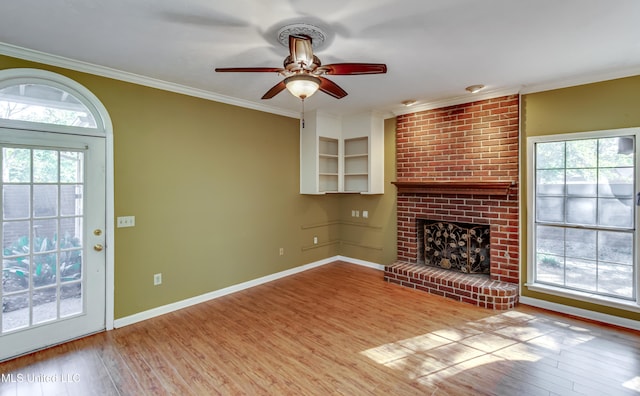 unfurnished living room featuring ceiling fan, ornamental molding, light hardwood / wood-style flooring, and a fireplace