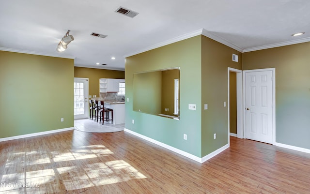 unfurnished room with light hardwood / wood-style flooring and crown molding